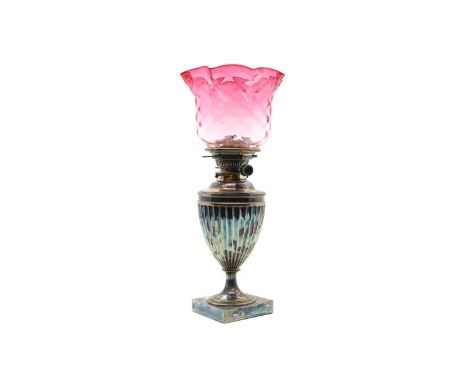 A silver-plated urn shaped oil lamp, 19th century, with a Hink's Duplex Patent mount, with a cranberry glass latticed glass s