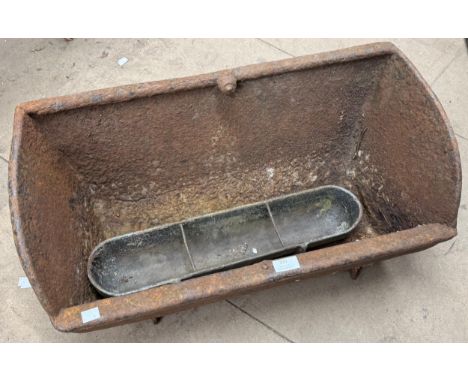 A cast iron feeding trough and another small trough