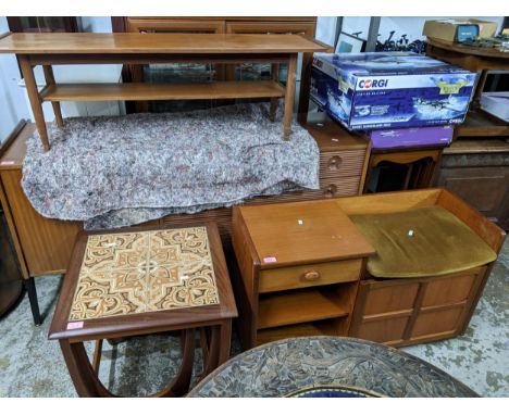 A mid-century teak coffee table with undertier, a teak telephone seat with drawer, open shelves, and panelled cupboard below 