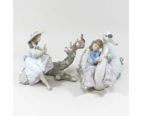 A Lladro porcelain figure group, of a girl seated upon a branch feeding squirrels, 17cm high, boxed, together with another of