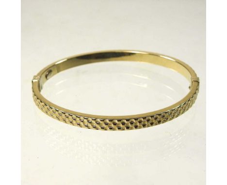 A modern 9 carat gold ladies bangle, of sprung textured design, 5.6g gross, 6.5cm wide