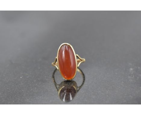 An oval carnelian ring having collared mount to open shoulders on a yellow metal loop stamped 9ct, size R &amp; approx 5.6g