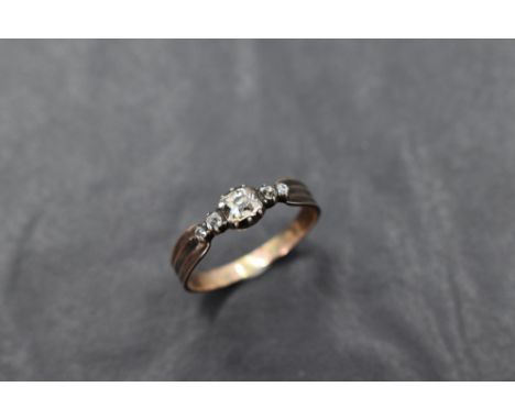 An antique five stone old cut diamond ring, possibly Georgian having black enamel decoration to ridged shoulders on a gold lo