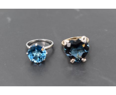 An over sized heart shaped, heat treated blue topaz ring having claw set mount spelling out the word 'love' on a 9ct gold loo