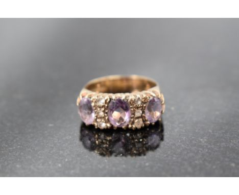 An amethyst trio ring interspersed by six cubic zirconia in a claw set panel mount on a 9ct gold loop. Size R and approx 4.5g