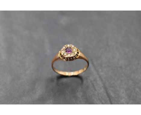 A Victorian ruby and seed pearl cluster ring in an indented circular gallery mount on a 15ct gold loop, size N &amp; approx 2