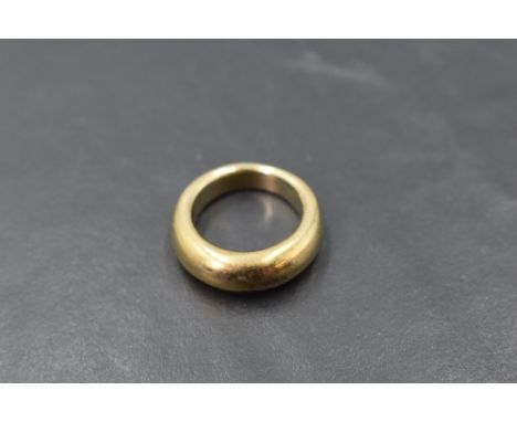 A yellow metal plain moulded band ring, marks worn, size K &amp; approx 10.9g