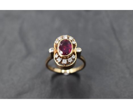 A ruby and diamond open cluster ring in an open collared mount with diamond set shoulders and yellow metal loop stamped 14ct,