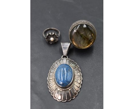 An American lapis lazuli oval pendant in a silver decorative mount bearing makers mark for Leonard James, an oversized silver