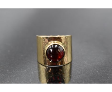 A 9ct gold band ring having a red cabouchon stone in a collared mount, size Q/R &amp; approx 7g