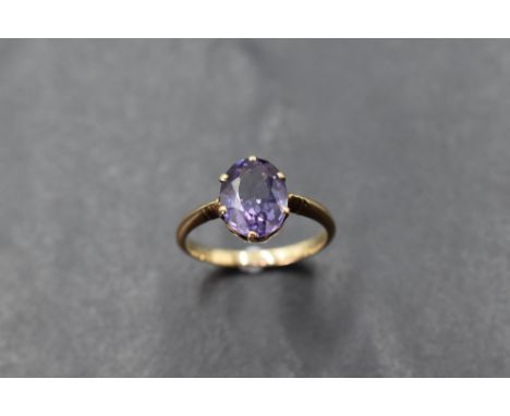 An amethyst solitaire ring in a 6 claw setting on a yellow metal loop, probably gold, size O &amp; approx 2.8g