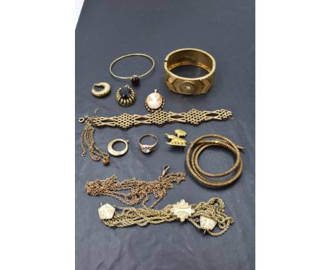 A tray of rolled gold jewellery including a hinged cuff bangle, coiled snake bangle, pendant, an Albertina chain, brooches et