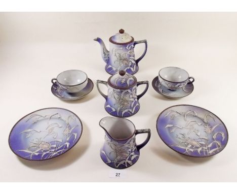 A Japanese porcelain teaset comprising: five cups and saucers, teapot, milk, sugar and six tea plates decorated stag beetles 