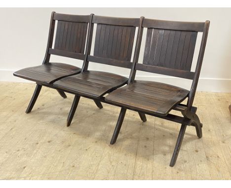 Heywood Bros and Wakefield Company, An early 20th century American stained beech three seat folding hall or cinema bench, wit