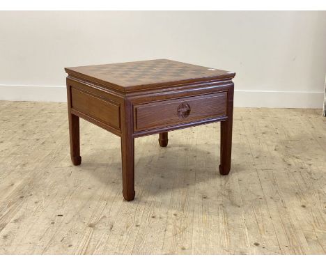 A Chinese style hardwood games table, the panelled top inlaid with chess board over one frieze drawer, raised on square mould