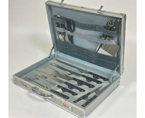 A Bachmayr aluminium case containing a set of stainless steel kitchen knives complete with carving knife, carving fork, chopp