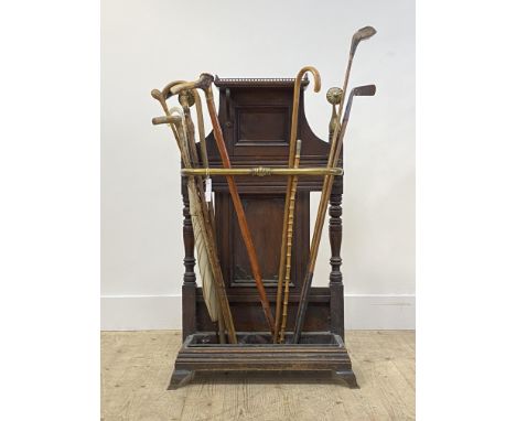 A Victorian oak and brass mounted stick stand, with galleried top over three division brass rail, panelled back and drip tray