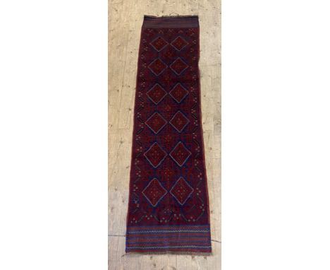 A Meshwani runner rug, the red field of geometric design 260cm x 65cm