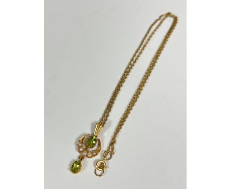 An Edwardian 9ct gold peridot and seed pearl crescent drop pendant, on trace link chain (pendant: 3.5cm) (3.23g)