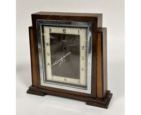 An Art Deco electric oak and walnut mantel clock, the rectangular chrome plated glazed front enclosing a silvered dial and wa