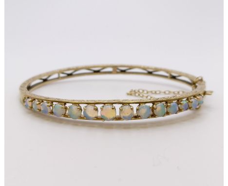 A 9ct gold and opal bangle, 10.1 g all in 