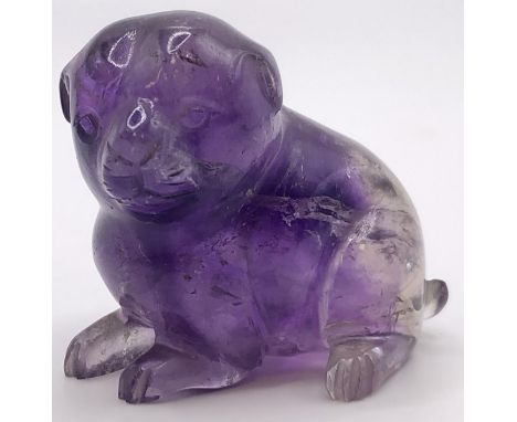 A purple stone carving of a puppy, 4 cm wide 