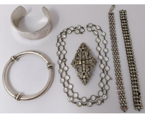 An Art Deco paste set clip brooch, a silver coloured metal bangle, a silver bangle, and two necklaces 