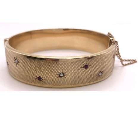 A 9ct gold, ruby and seed pearl bangle, Chester 1959, 28 g 