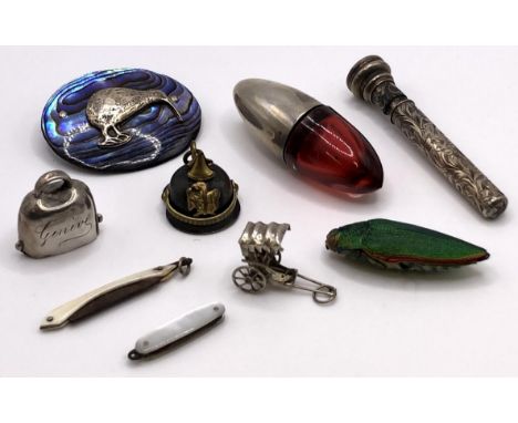 A ruby glass and silver miniature perfume bottle, a silver pencil, an oval brooch, and assorted charms (9) 
