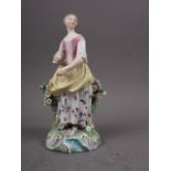 An 18th century Derby figure of a girl, 7" high (damages)