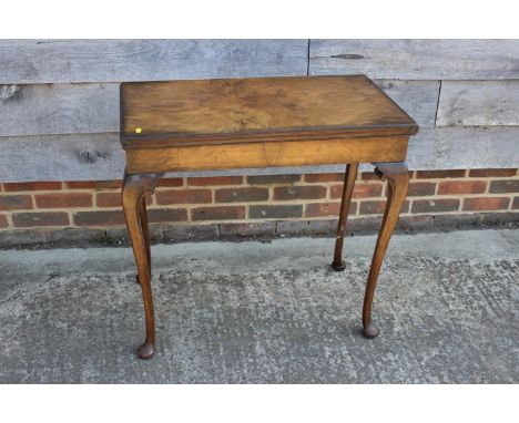 A figured walnut rectangular fold-over top card table, on cabriole supports and pad feet, 30" wide x 16" deep x 29" high