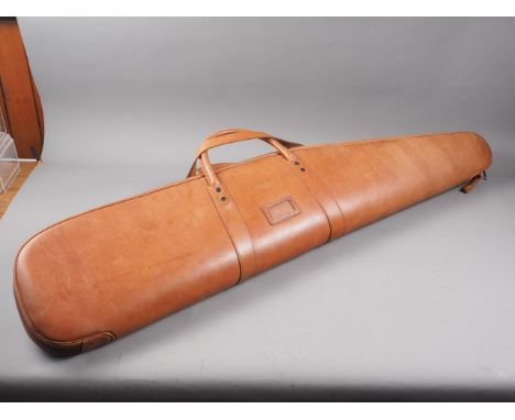 A Conway, London, tan leather rifle carry bag with textured sponge interior, 47 1/2" long, and a similar leather flask case, 