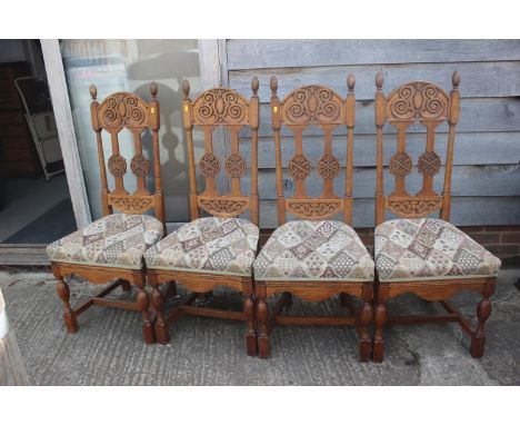 A set of four carved light oak high backed dining chairs with upholstered floral pattern seats, a dark oak drop leaf table, o
