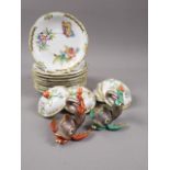 A collection of Herend "Queen Victoria" pattern saucers and chocolate cup covers, two Herend dolphin