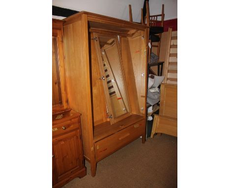 A pair of Ercol light oak wardrobes enclosed panel doors with fitted interior mirror over one long drawer, on splay supports,