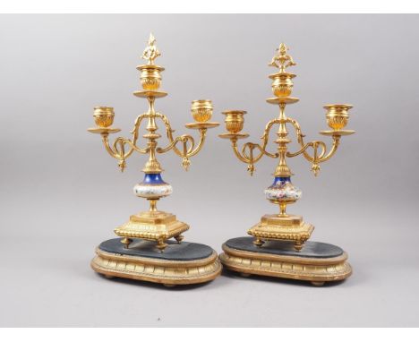 A pair of gilt metal and porcelain bird decorated three-light candelabra, on ebonised bases, a mahogany and inlaid mantel clo