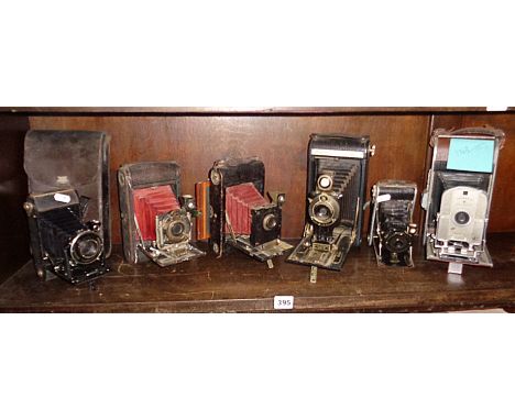 Kodak Eastman No.4 red bellows plate camera, four similar Kodak bellows cameras and a 1940s Polaroid Land camera
