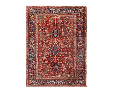 Heriz Carpet Northwest Iran, Circa 1910The madder field of serrated leaves, flowers and stylised plants centred by a pale blu