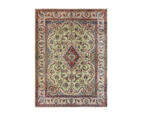 Tabriz CarpetNorthwest Iran, Circa 1950The faded pale mint field of palmettes and leafy vines centred by a medallion, framed 