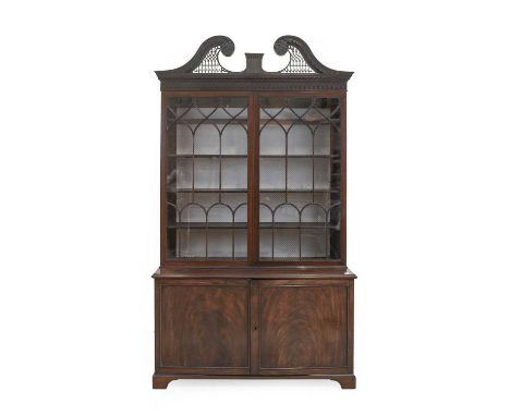 A Late George III Mahogany Bookcase, early 19th century, the fret carved scrolled swan neck pediment above a blind fret mould