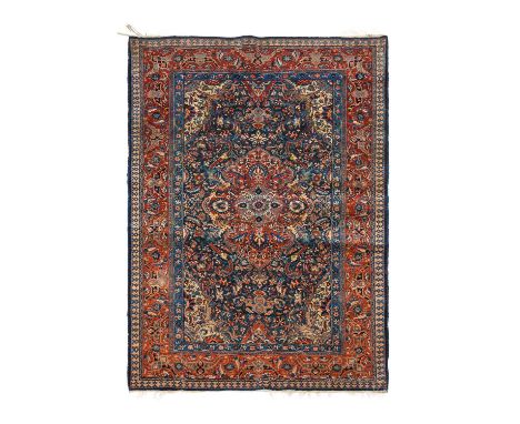 Good Kashan CarpetCentral Iran, circa 1940The deep indigo field centred by a cusped raspberry flowerhead medallion, framed by