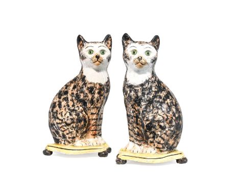 A Pair of Pearlware Cats, 1st half 19th century, naturalistically modelled seated with black and ochre markings on shaped rec