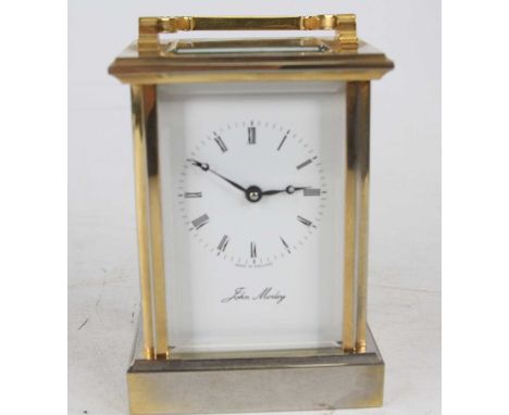 A late 20th century John Morley lacquered brass English carriage clock, having a signed white enamel Roman dial, visible plat