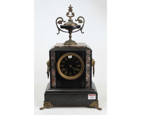 A late 19th century polished black slate and marble mantel clock surmounted with a pedestal urn and having further gilt brass