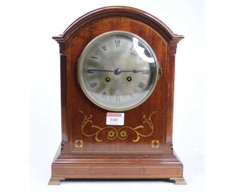 An Edwardian mahogany and brass inlaid dome top mantel clock having an unsigned silvered Roman dial with twin winding holes f