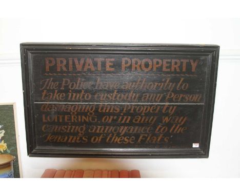 A vintage wooden sign inscribed 'Private Property - the Police have authority to take into custody any person damaging this p