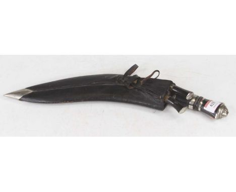 A 20th century kukri having a polished steel blade and lion mask capped lacquered horn handle, housed in leather sheath, leng