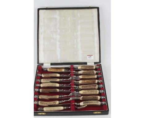 A cased set of horn handled stainless steel cutlery comprising eight knives and forks