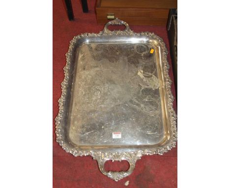 A Victorian style silver plated twin handled drinks tray, having engraved ground and raised leaf cast rim, 77cm 