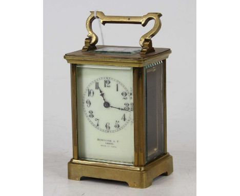 An early 20th century lacquered brass carriage clock, having a visible platform escapement, the white enamelled dial showing 
